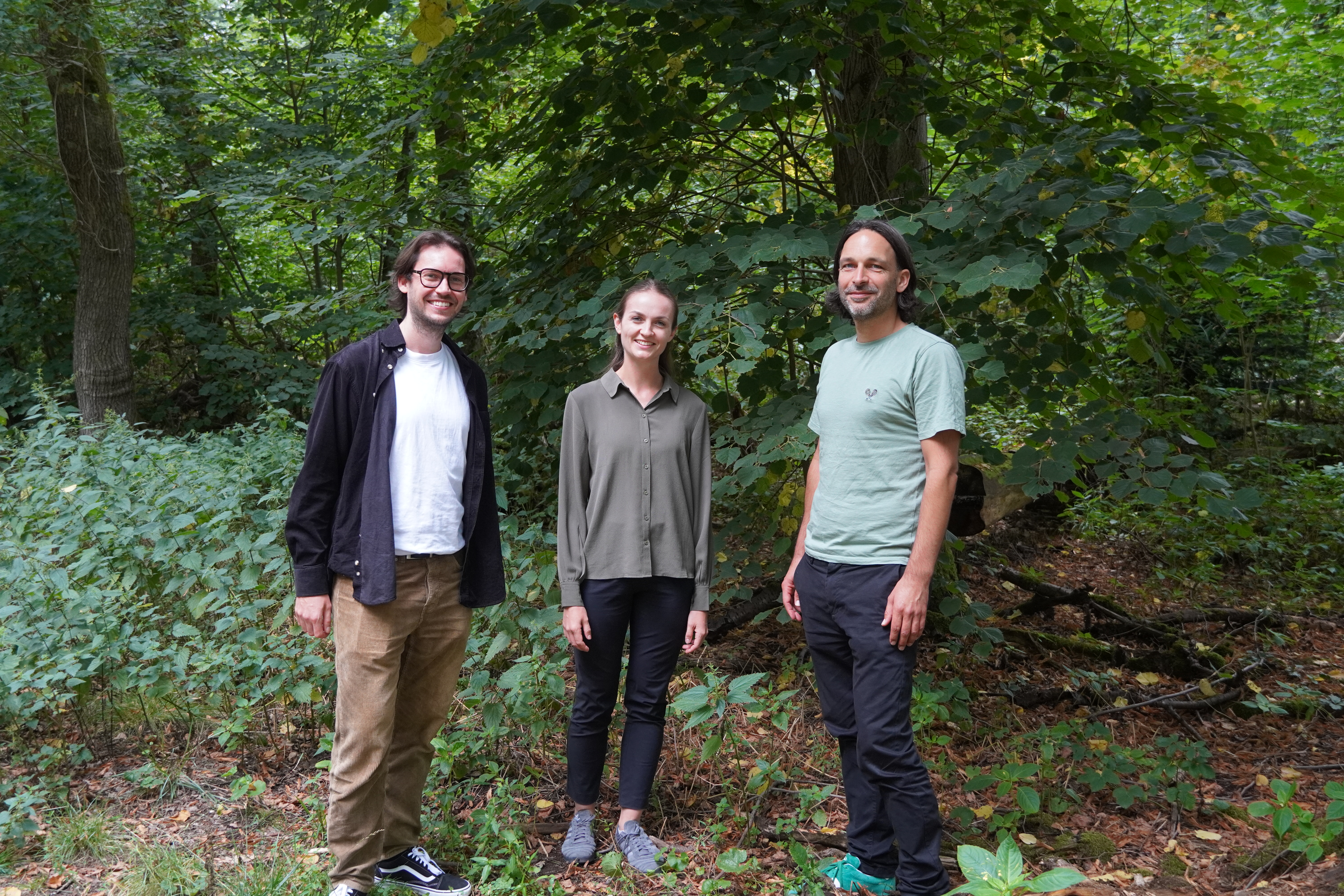 Jan Tenbrock (PRIMAKLIMA, links), Deborah Werheit (TARGOBANK Stiftung, Mitte) und Lars Forjahn (PRIMAKLIMA, rechts) bei einem Waldspaziergang in Köln. 