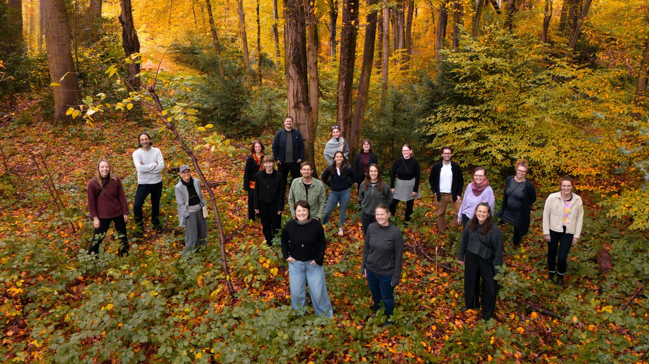 Das Team von PRIMAKLIMA e.V. in einem bunten Herbstwald.