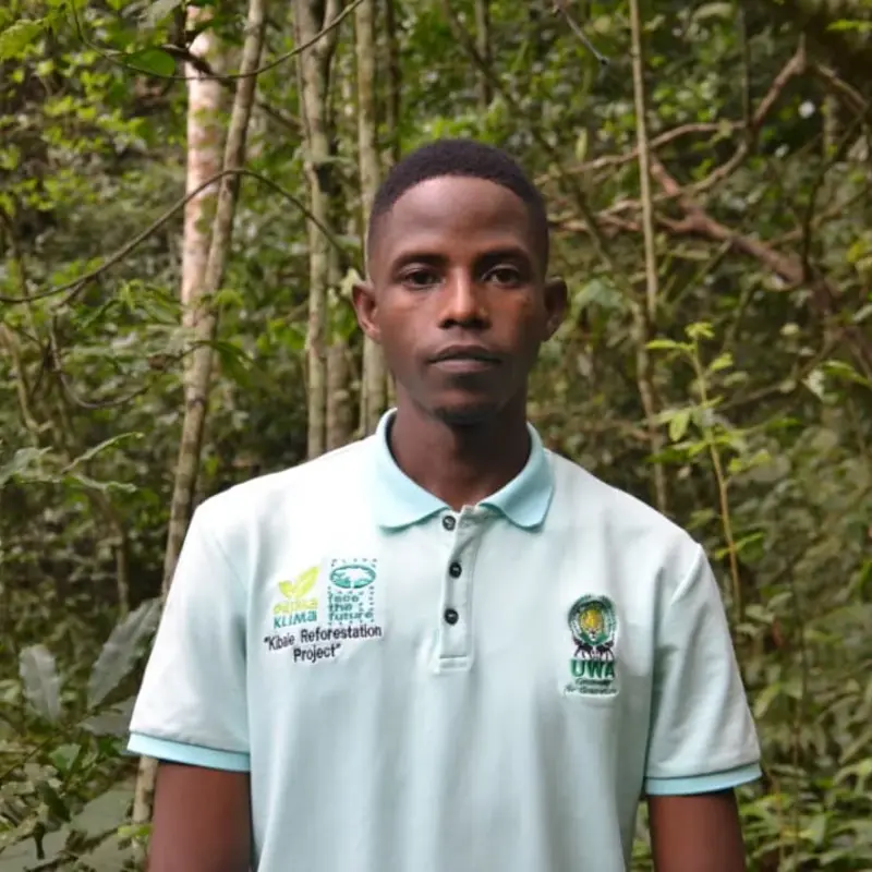 Kato Micheal steht im Wald des Kibale Restoration Projects in Uganda