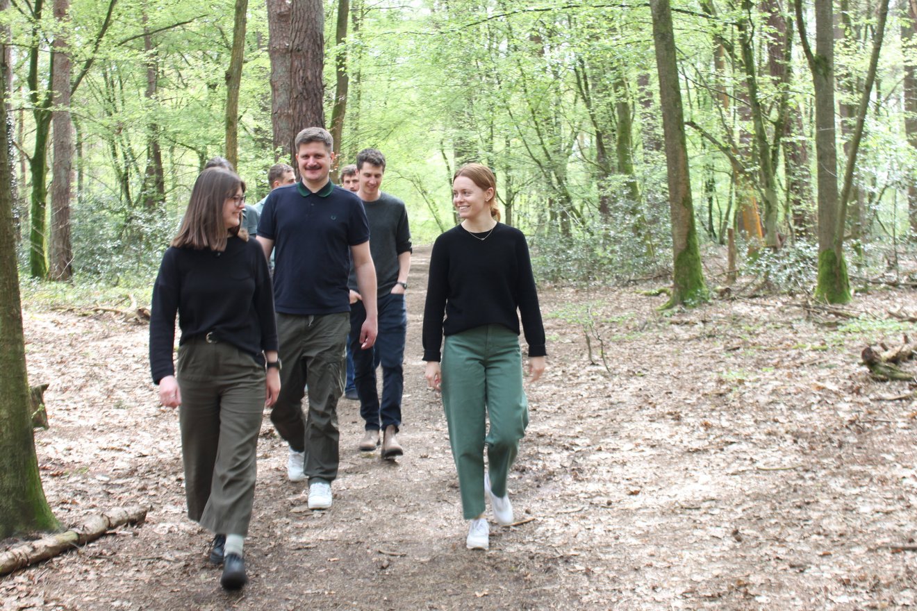 Mitarbeitende von PRIMAKLIMA und Taking Root im Wald unterwegs.