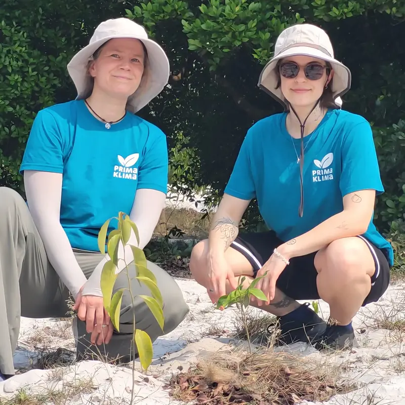 Henriette und Alina von PRIMAKLIMA sitzen vor jungen Setzlingen im Projekt in Vietnam 